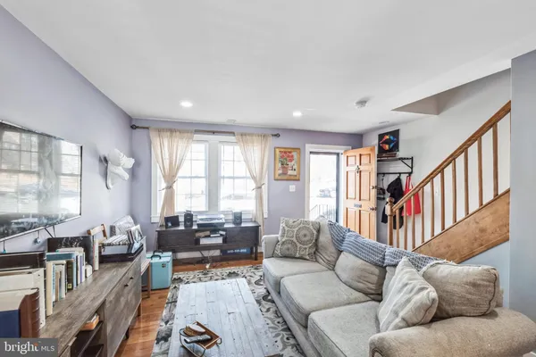 a living room with furniture wooden floor and a large window