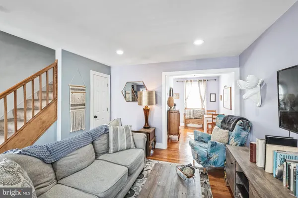 a living room with furniture a flat screen tv and a large window
