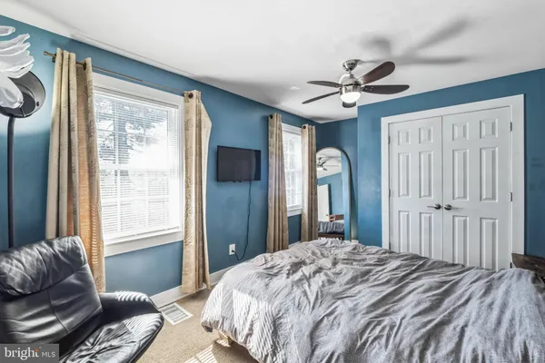 a bedroom with a bed ceiling fan and a window