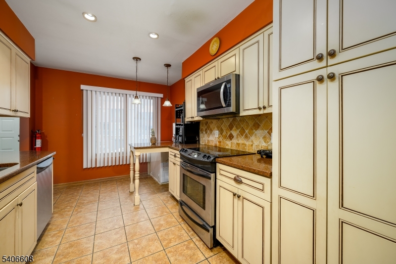 900 Valley Road, Unit D1O Clifton, NJ 07013 - Photo 7 of 16 a kitchen with stainless steel appliances a stove microwave and cabinets