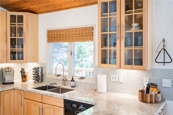 a kitchen with granite countertop sink and cabinets