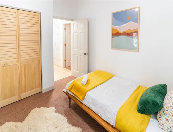 a bedroom with a bed and a painting on the wall