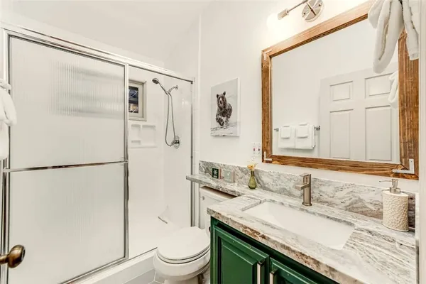 a bathroom with a granite countertop sink toilet and shower