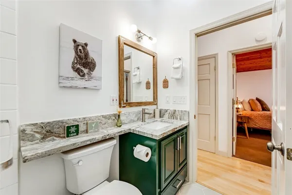 a en suite bathroom with a granite countertop sink and a mirror