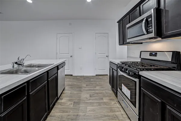 a kitchen with stainless steel appliances granite countertop a stove and a microwave
