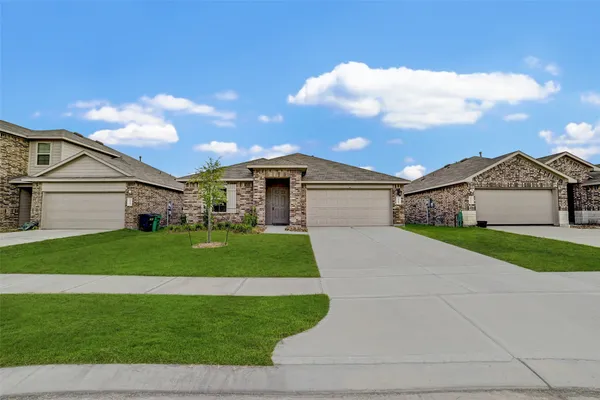 a front view of a house with a garden and yard