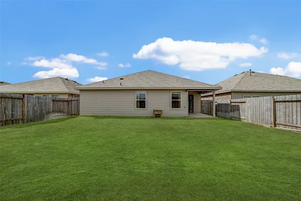 a view of a yard in front of a house with large trees