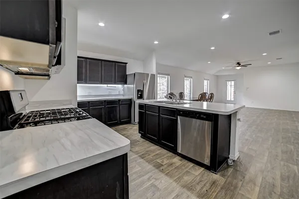 a kitchen with stainless steel appliances granite countertop a stove a sink a refrigerator and a oven