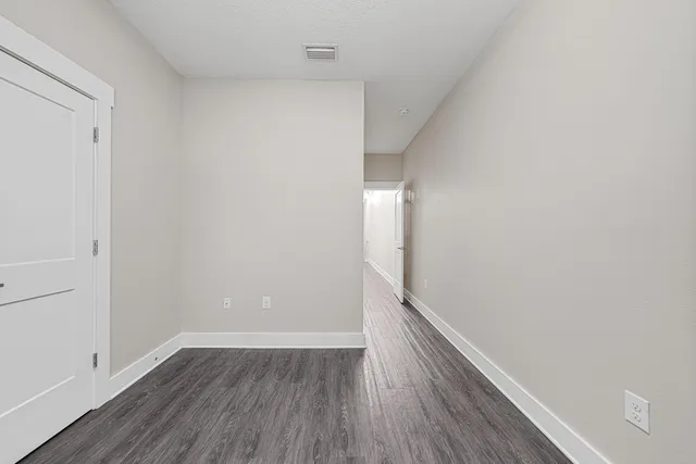 a view of an empty room with wooden floor
