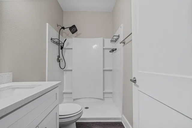 a bathroom with a granite countertop sink toilet and shower