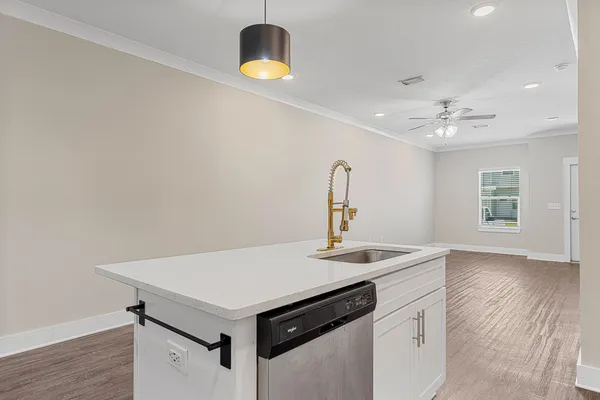 a kitchen with a stove a sink and a wooden floor