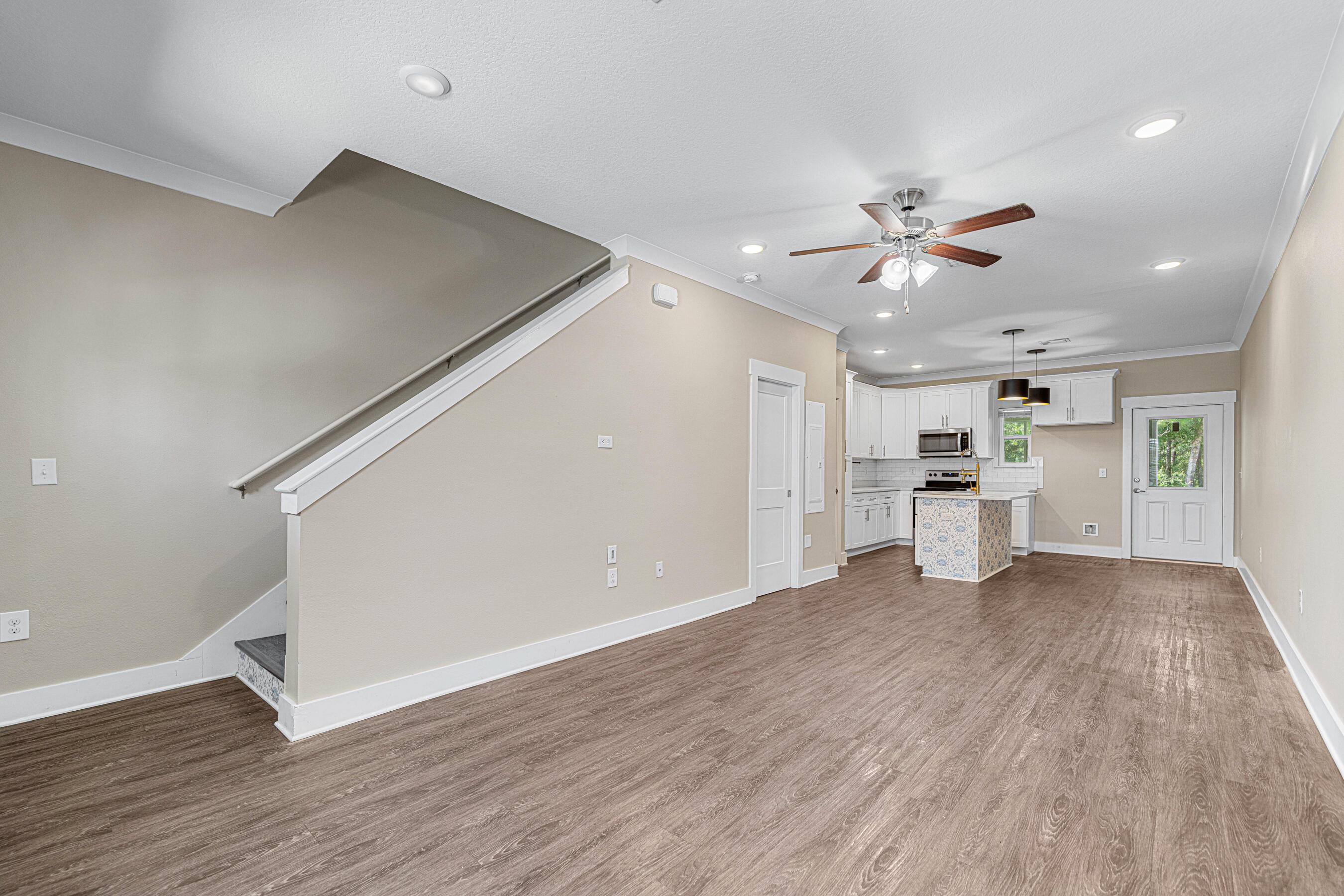 182 North Sand Palm Road Freeport, FL 32439 - Photo 10 of 38 a view of a kitchen with wooden floor and a ceiling fan