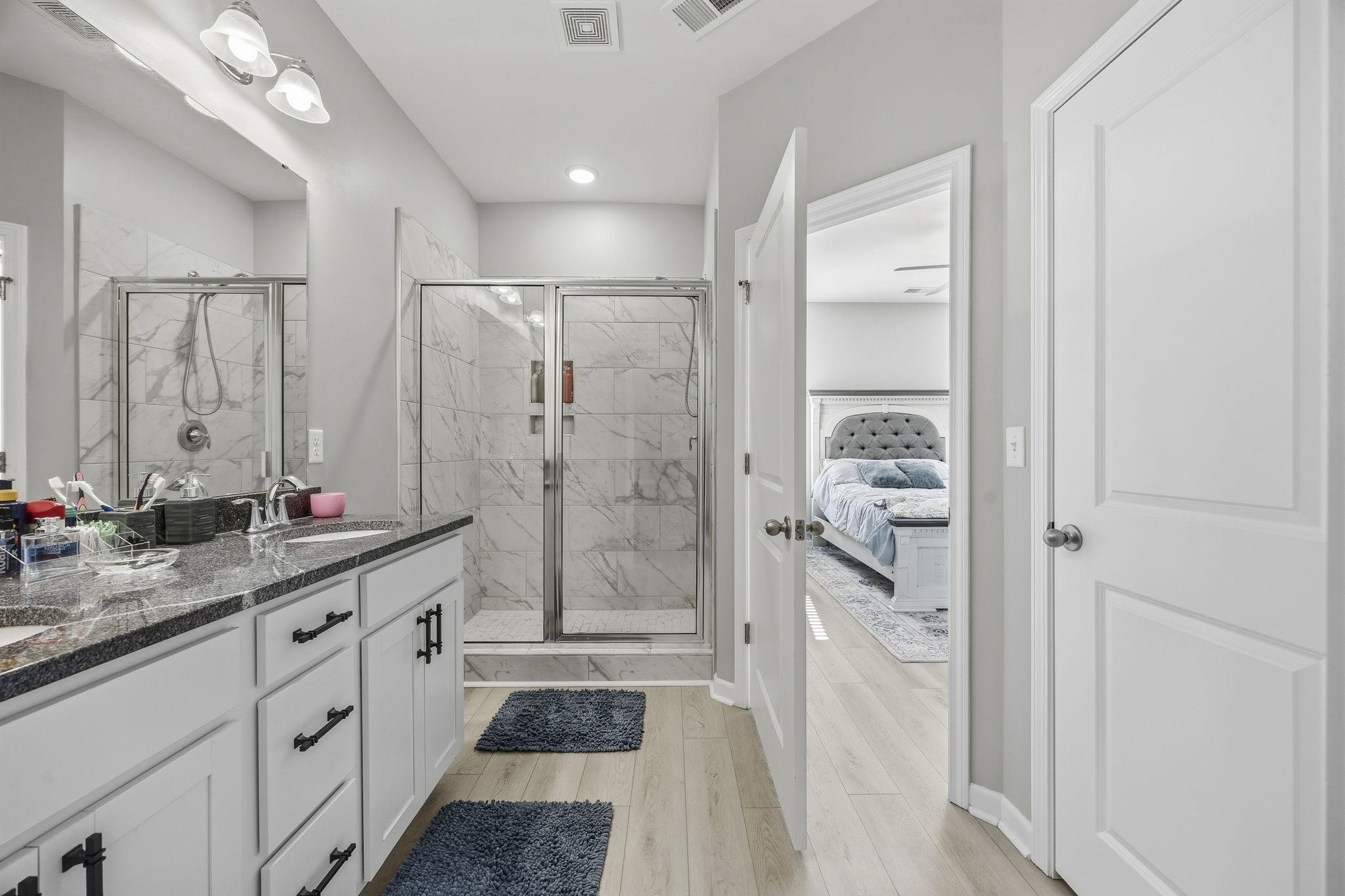 1010 Log Cabin Road Loris, SC 29569 - Photo 17 of 40 Bathroom with a marble finish shower, double vanity, ensuite bathroom, and light wood-style floors