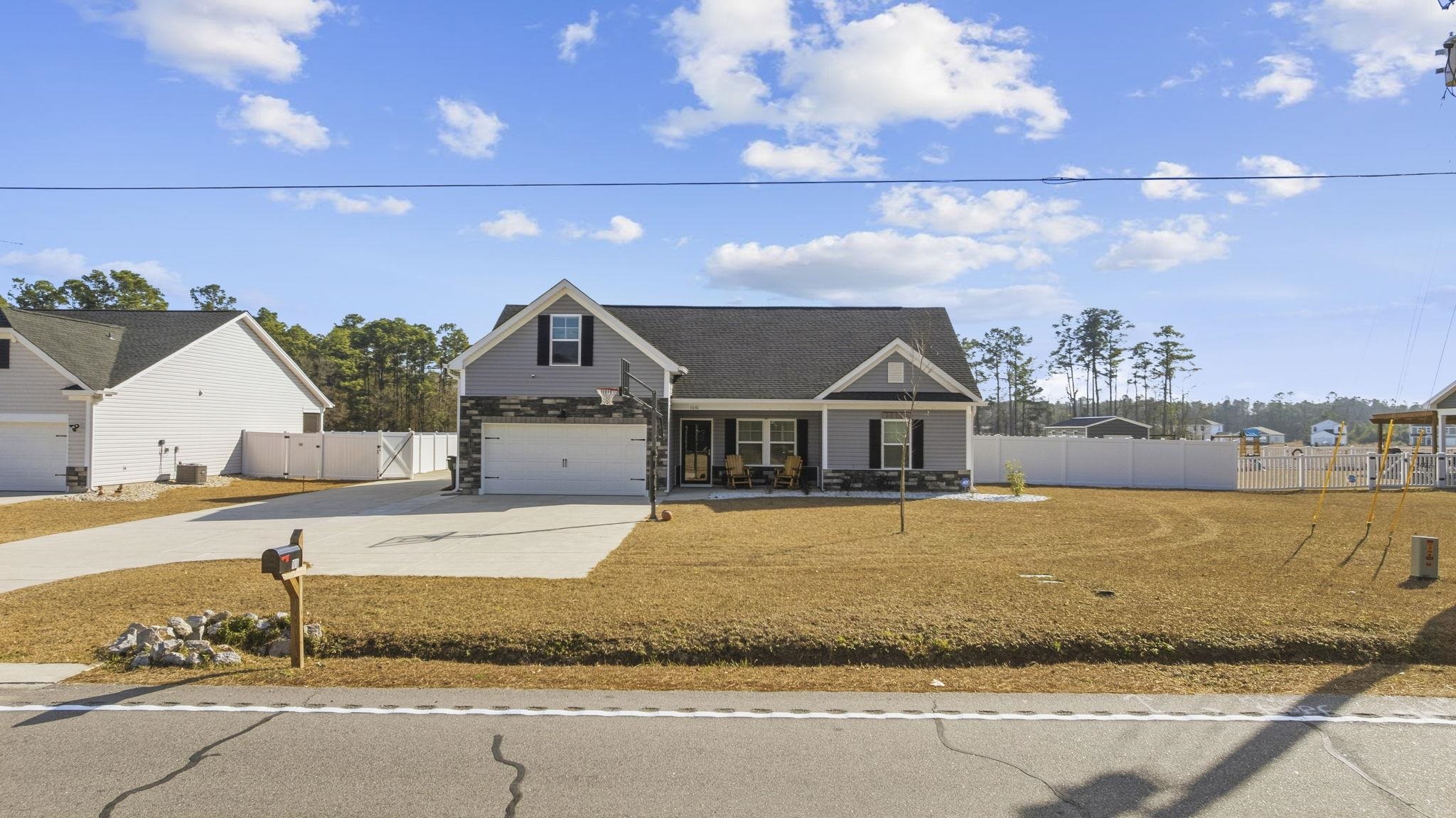 1010 Log Cabin Road Loris, SC 29569 - Photo 2 of 40 Traditional home featuring driveway, a gate, roof with shingles, covered porch, and stone siding