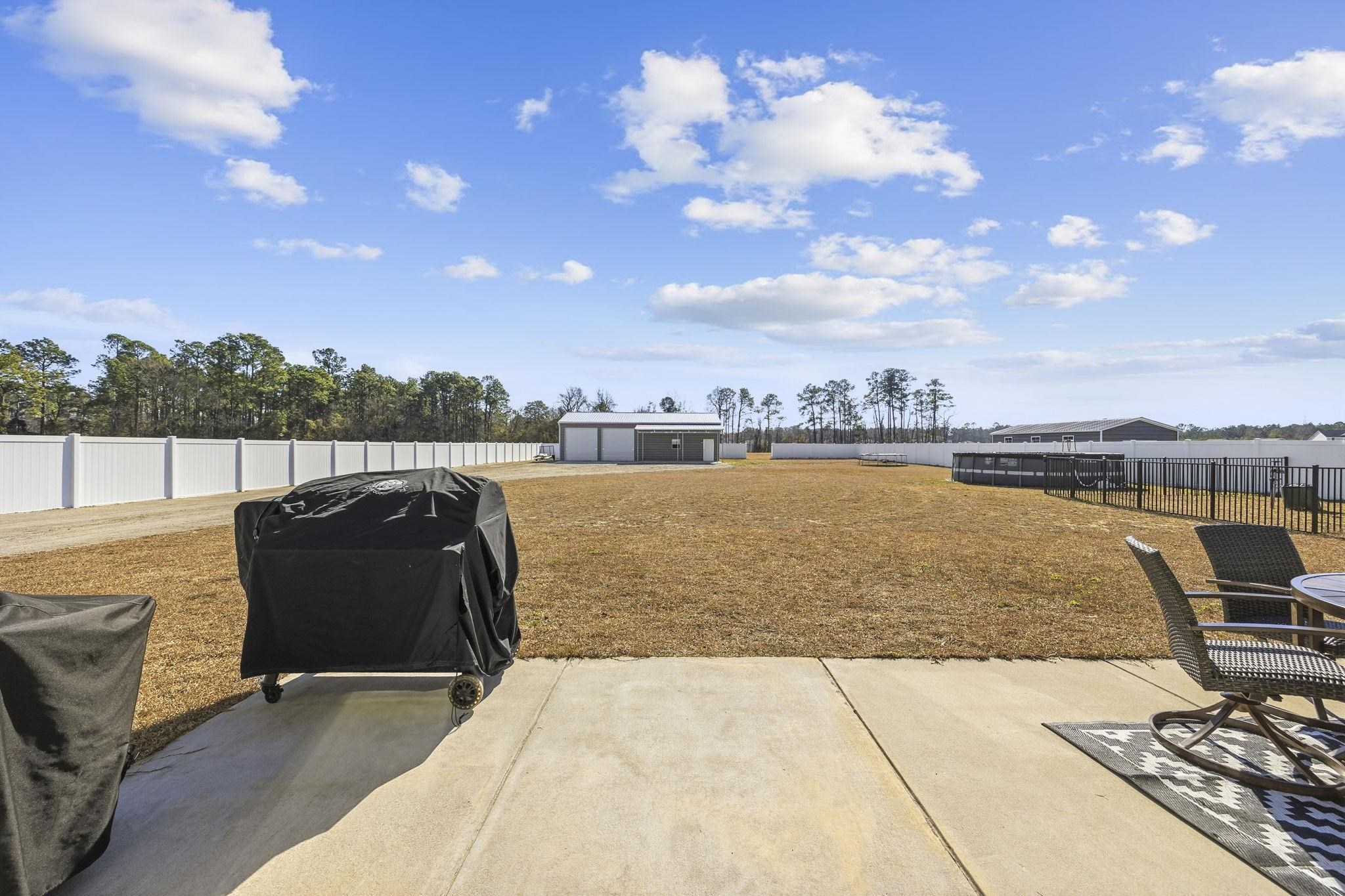 1010 Log Cabin Road Loris, SC 29569 - Photo 24 of 40 Fenced backyard with a patio area, a grill, and an outdoor structure