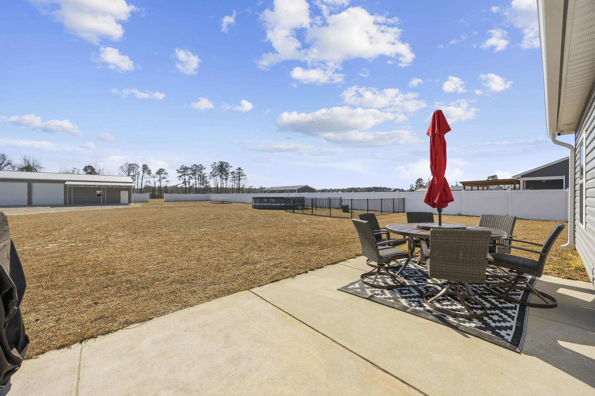 1010 Log Cabin Road Loris, SC 29569 - Photo 25 of 40 Fenced backyard with outdoor dining area, a patio area, and an outdoor structure