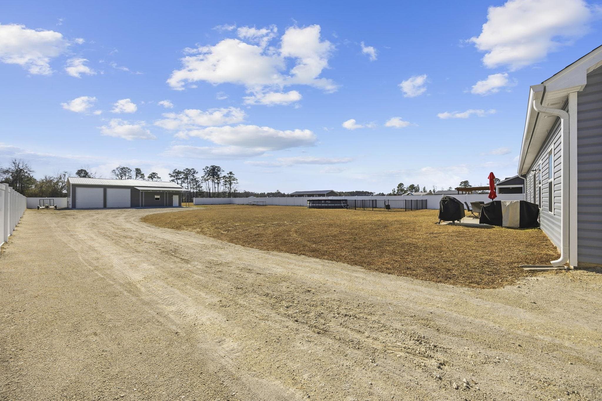1010 Log Cabin Road Loris, SC 29569 - Photo 26 of 40 View of yard with an outdoor structure, driveway, and a detached garage