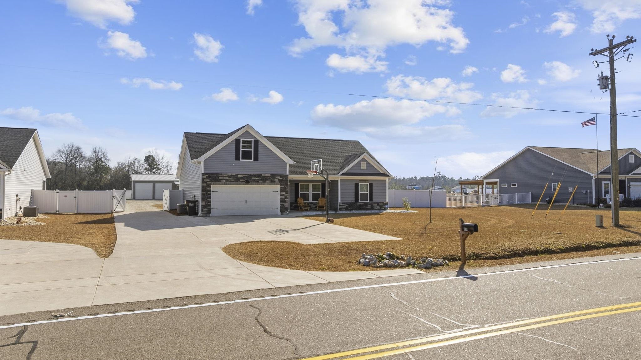 1010 Log Cabin Road Loris, SC 29569 - Photo 3 of 40 View of front of home featuring a gate, concrete driveway, and stone siding