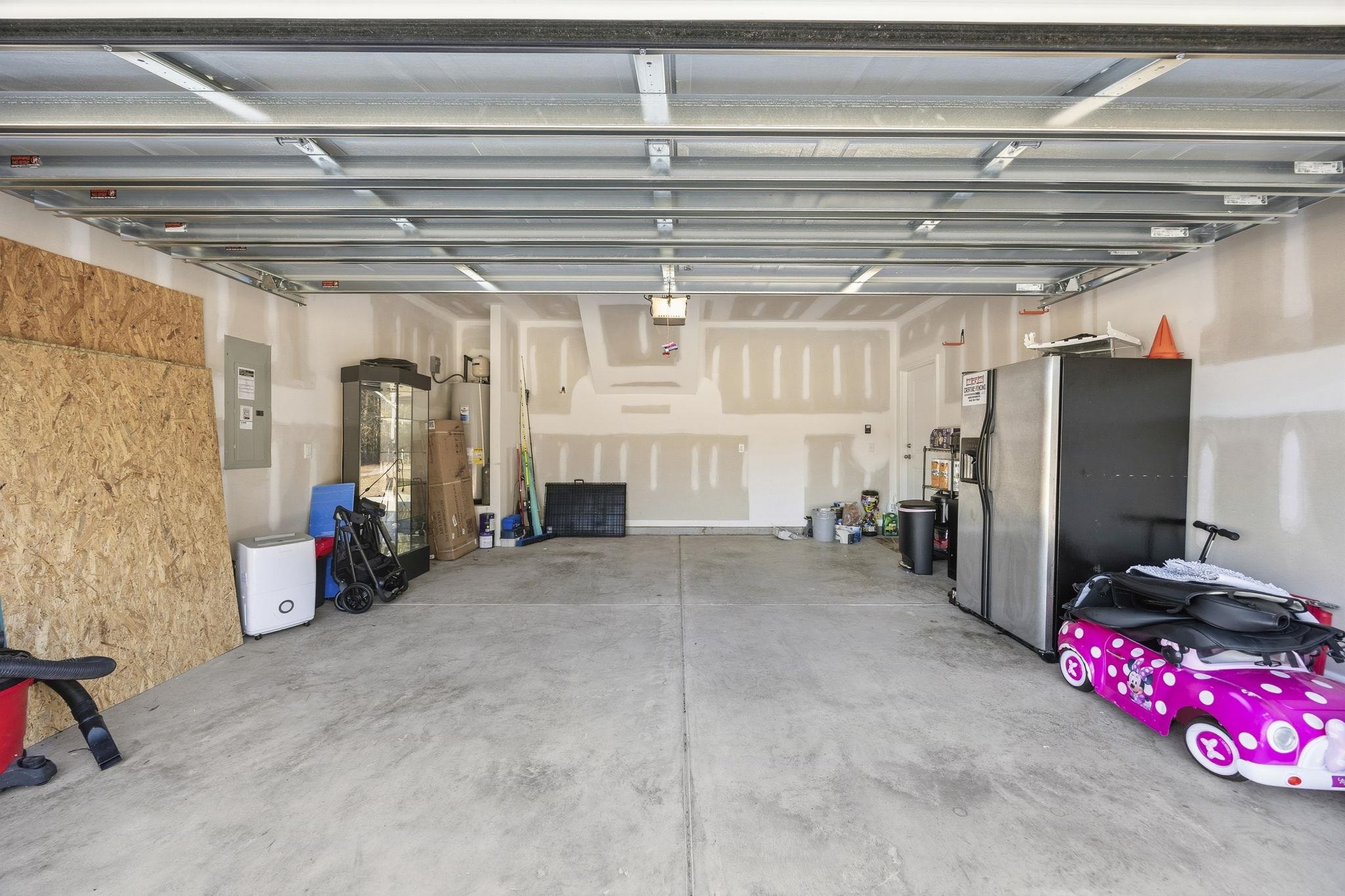 1010 Log Cabin Road Loris, SC 29569 - Photo 32 of 40 Garage with stainless steel refrigerator with ice dispenser, electric panel, and electric water heater