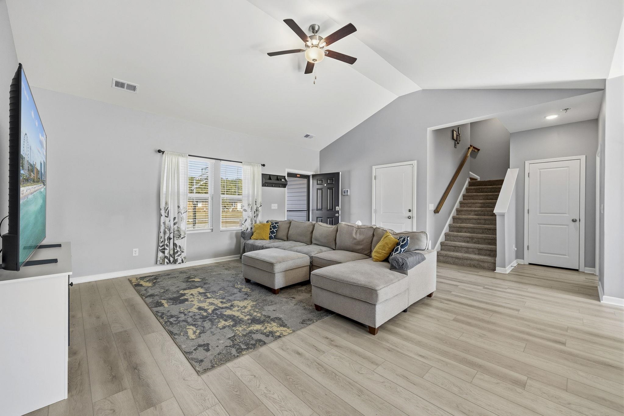 1010 Log Cabin Road Loris, SC 29569 - Photo 8 of 40 Living room featuring stairs, light wood-style flooring, a ceiling fan, and high vaulted ceiling