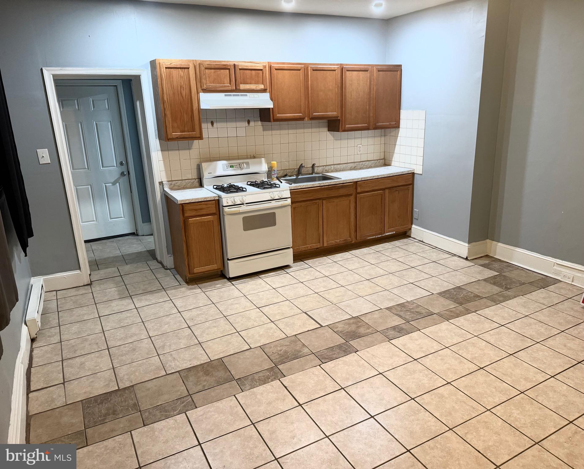 1328 North 54th Street, Unit 1 Philadelphia, PA 19131 - Photo 4 of 6 a kitchen with stainless steel appliances a sink a stove top oven a counter space and cabinets