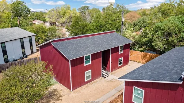 a view of a wooden house with a tree