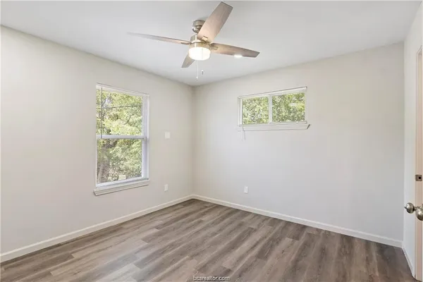 an empty room with a window and a ceiling fan