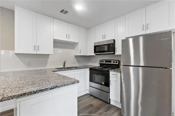 a kitchen with stainless steel appliances granite countertop a refrigerator stove a sink and dishwasher