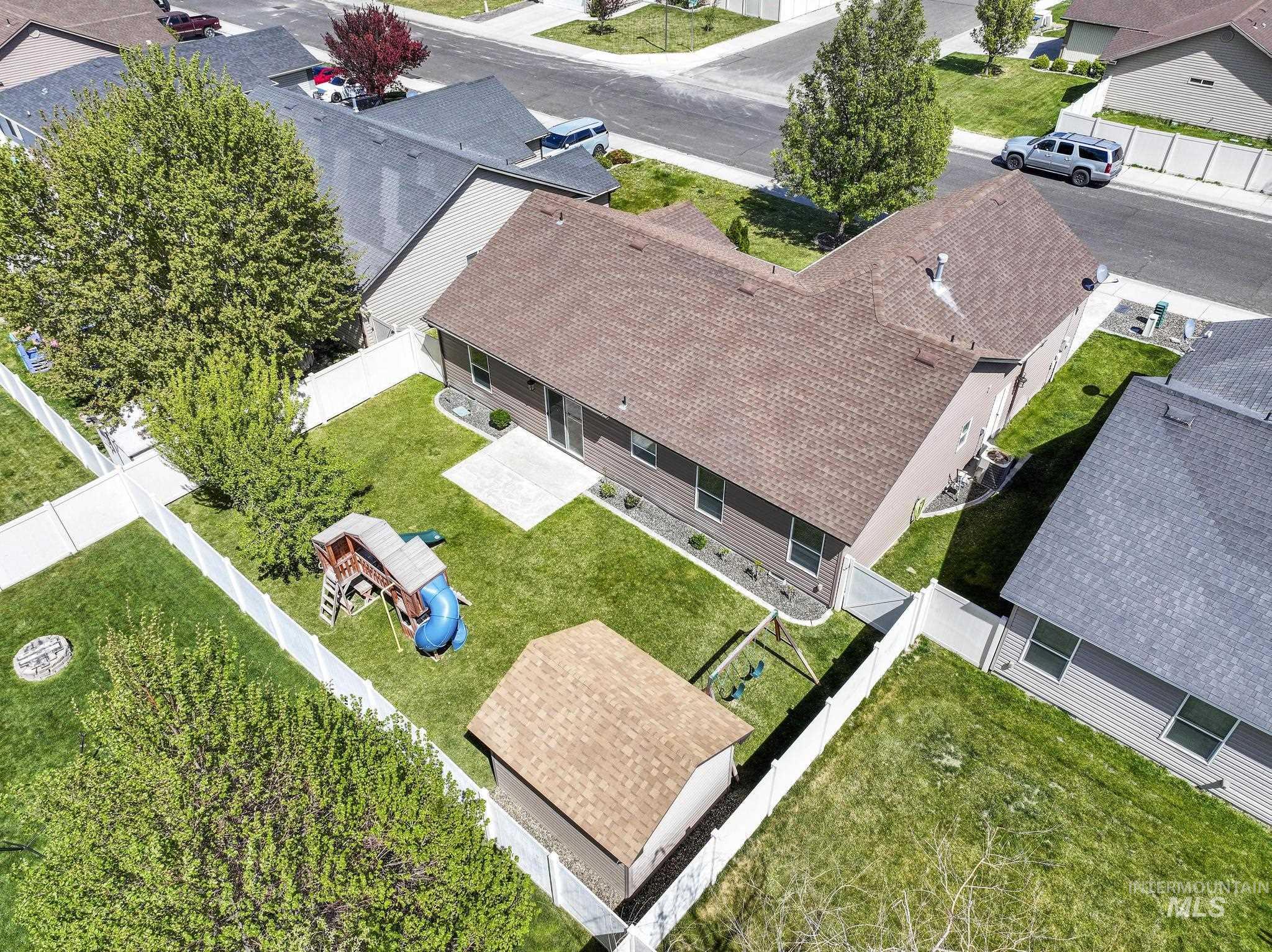 446 Noble Street Twin Falls, ID 83301 - Photo 32 of 42 Expansive rear yard featuring a manicured lawn, concrete patio, and mature perimeter trees