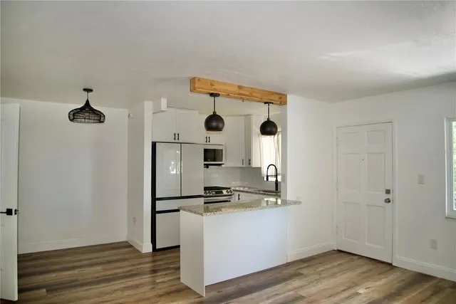 a kitchen with a refrigerator and a stove top oven