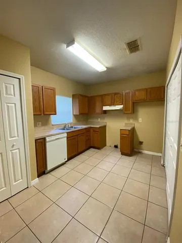 a large kitchen with a stove a sink dishwasher and a refrigerator