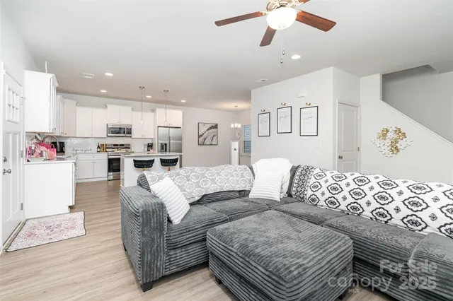 a living room with furniture and kitchen view