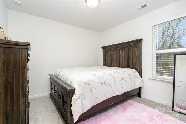 a bed sitting in a bedroom next to a window