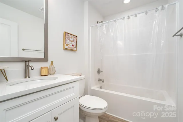 a bathroom with a granite countertop sink a toilet and a bathtub