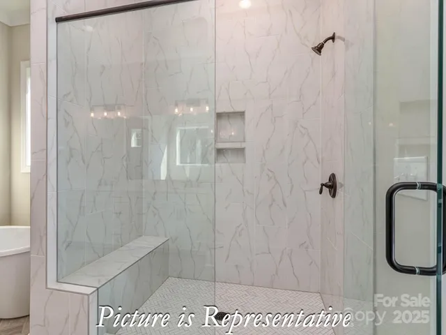 a view of a livingroom with wooden floor a ceiling fan and windows