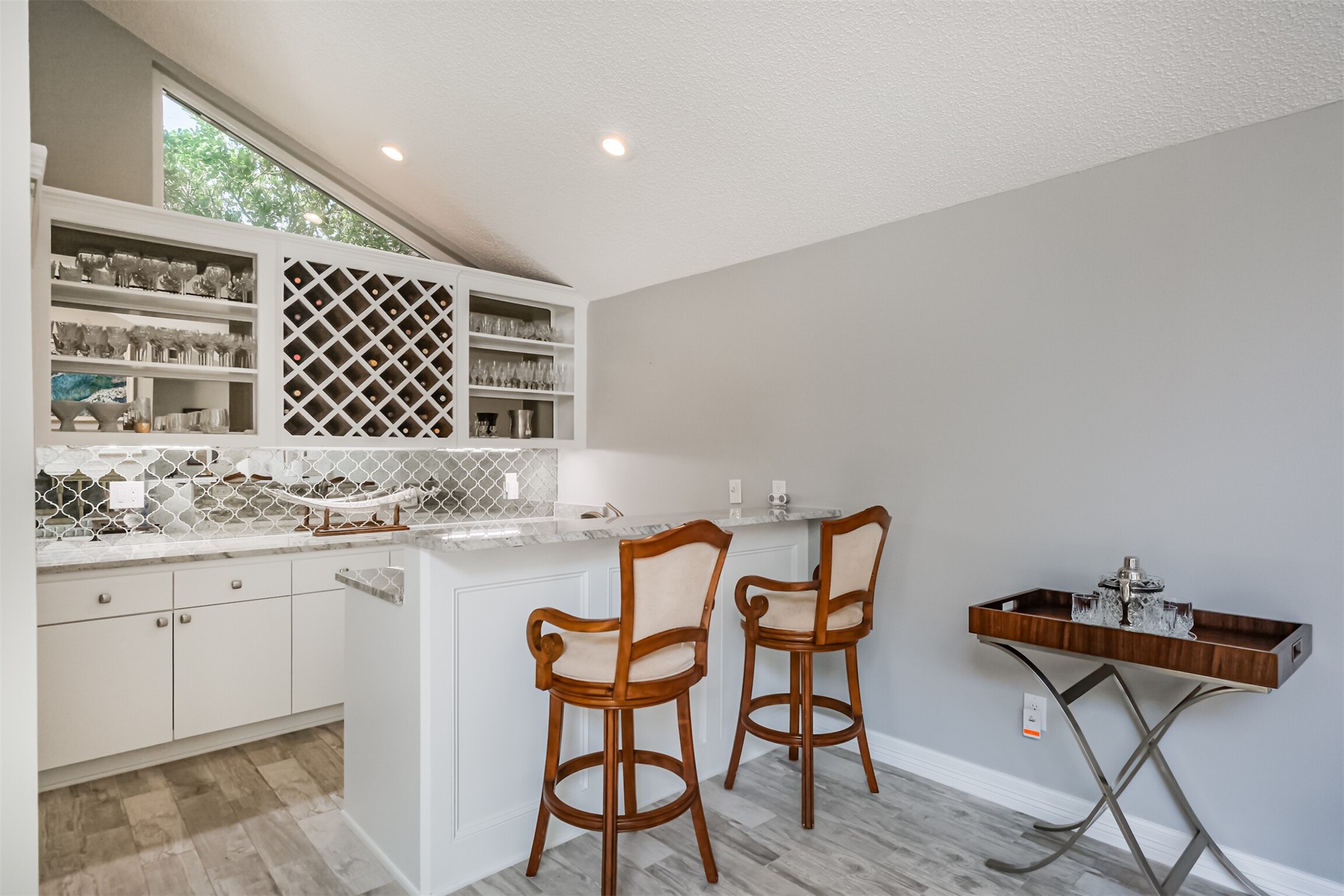 1007 Arrow Hill Road Houston, TX 77077 - Photo 6 of 48 The wet bar features granite counters with glass/tile backsplash, built-in wine rack and shelves, cabinetry and sink.