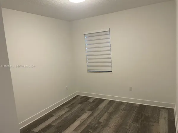 a view of a small space with wooden floor and a window