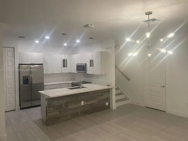a kitchen with kitchen island a sink stainless steel appliances and cabinets