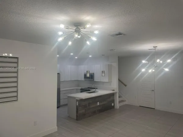 a large kitchen with kitchen island a sink stainless steel appliances and cabinets