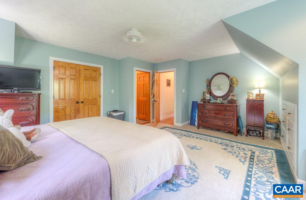 2959 Martin Kings Road Charlottesville, VA 22902 - Photo 21 of 44 a spacious bedroom with a bed a dresser and mirror