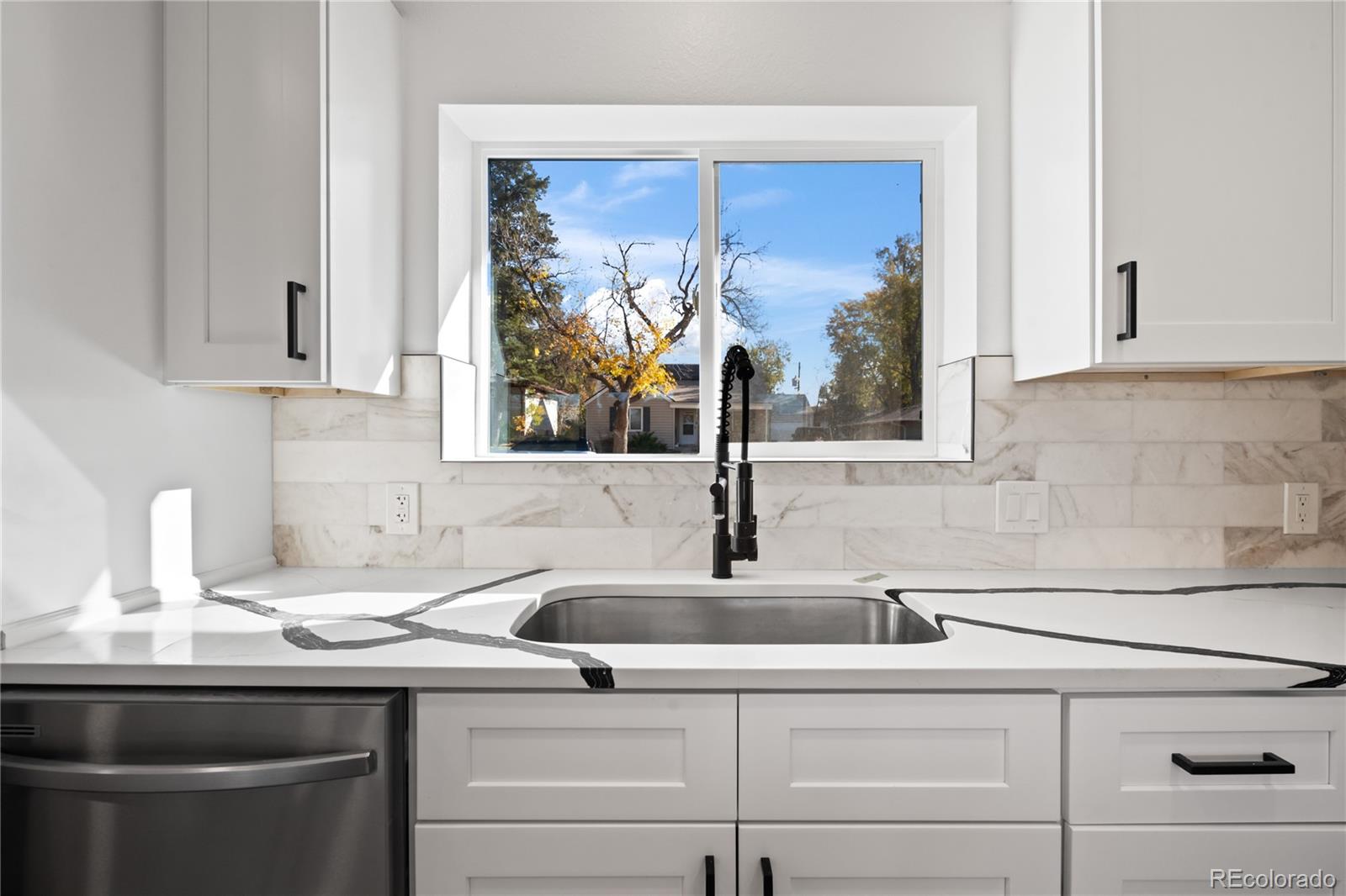 7921 Raleigh Street Westminster, CO 80030 - Photo 14 of 43 a kitchen with a sink and cabinets