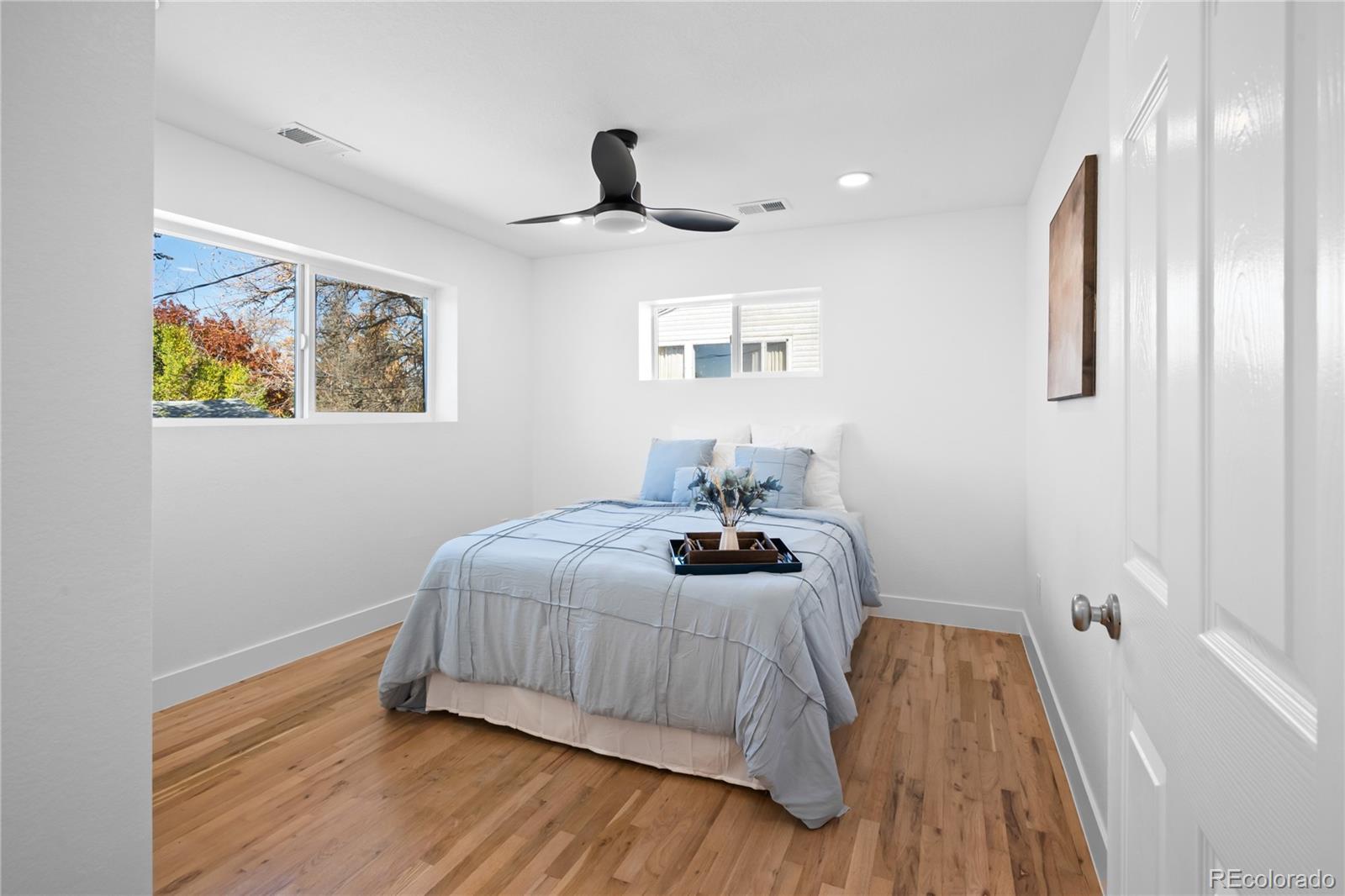 7921 Raleigh Street Westminster, CO 80030 - Photo 27 of 43 a bedroom with a bed and a chandelier