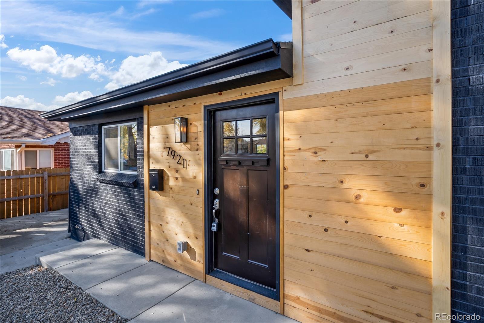 7921 Raleigh Street Westminster, CO 80030 - Photo 3 of 43 a front view of a house with a glass door