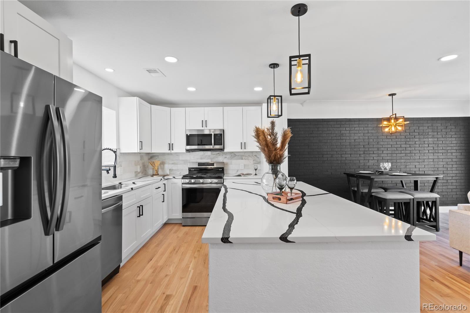 7921 Raleigh Street Westminster, CO 80030 - Photo 6 of 43 a kitchen with a sink stainless steel appliances and refrigerator