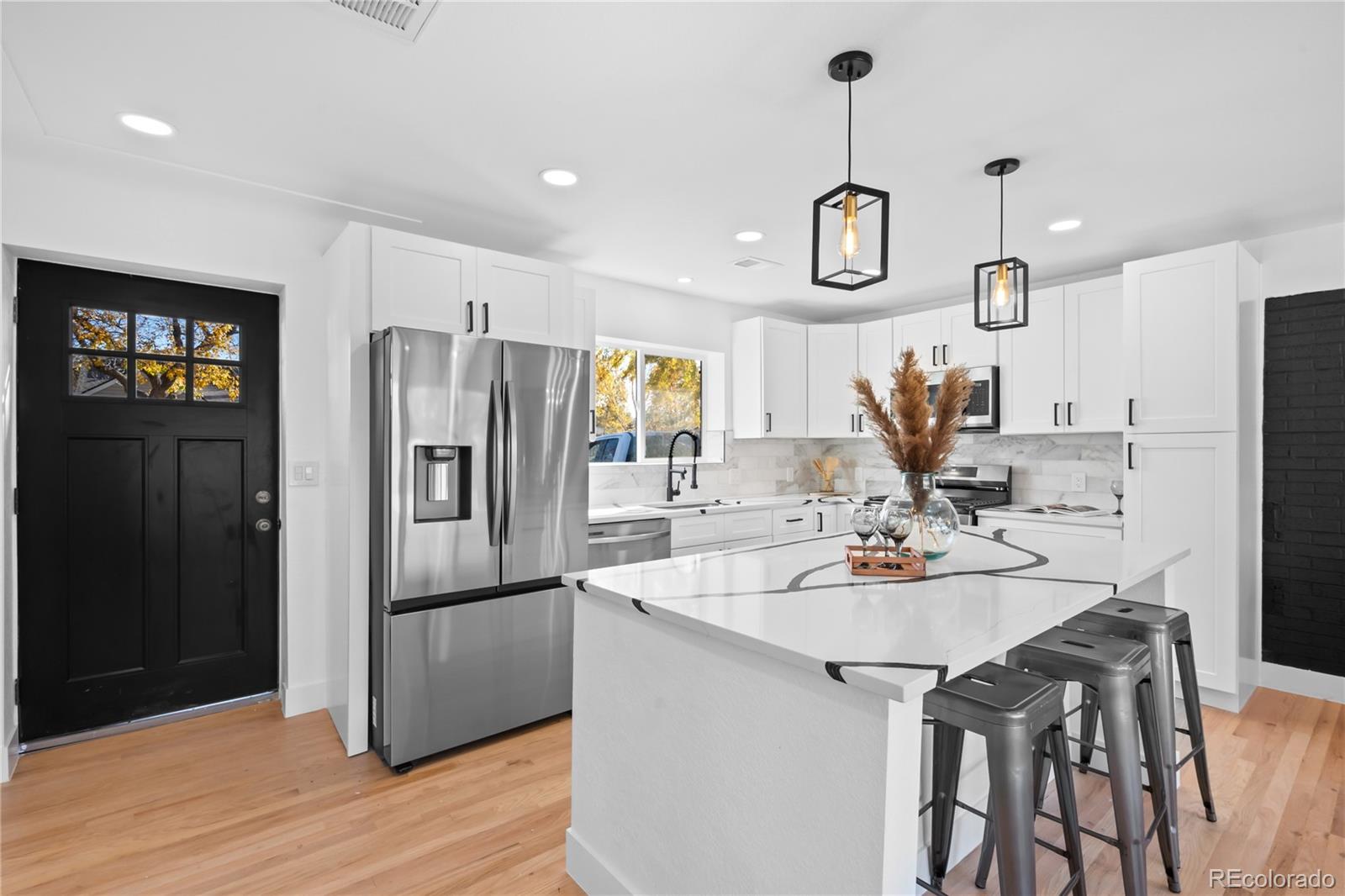 7921 Raleigh Street Westminster, CO 80030 - Photo 7 of 43 a kitchen with a refrigerator a sink dishwasher and wooden cabinets with wooden floor