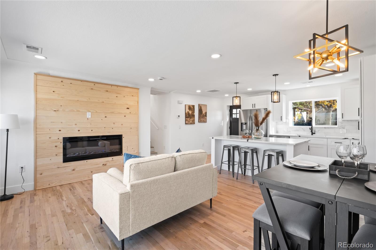 7921 Raleigh Street Westminster, CO 80030 - Photo 9 of 43 a living room with furniture a fireplace and a flat screen tv