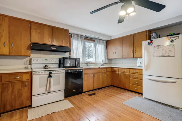 a kitchen with a refrigerator and a stove top oven