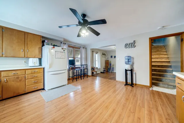 a kitchen with a refrigerator and wooden floors