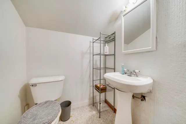a bathroom with a sink toilet and mirror