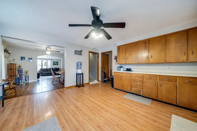 a kitchen with stainless steel appliances granite countertop wooden floors and view of living room